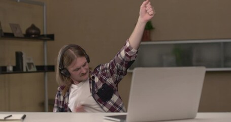 Young man is listening to music with airheads and closed eyes