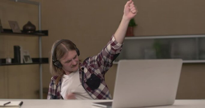 Young man is listening to music with airheads and closed eyes