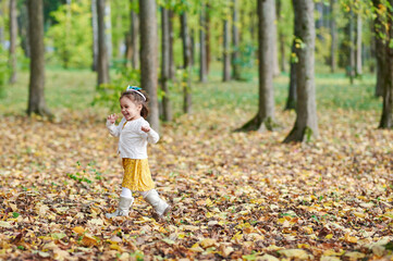 Toddler girl run in autumn forest