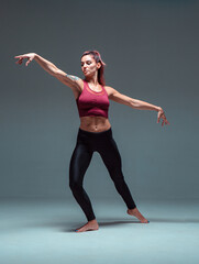 Full-length portrait of a modern female dancer dancing in sportswear.