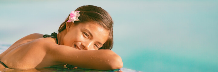 Resort vacation wellness pampering Asian young woman happy relaxing in pool panoramic banner. - obrazy, fototapety, plakaty