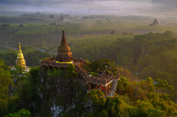 Naklejka premium View of Buddhism temple Thamma Park padoga on hill at sunrise in Ban Khao Na Nai village in Phanom, Surat Thani, Thailand