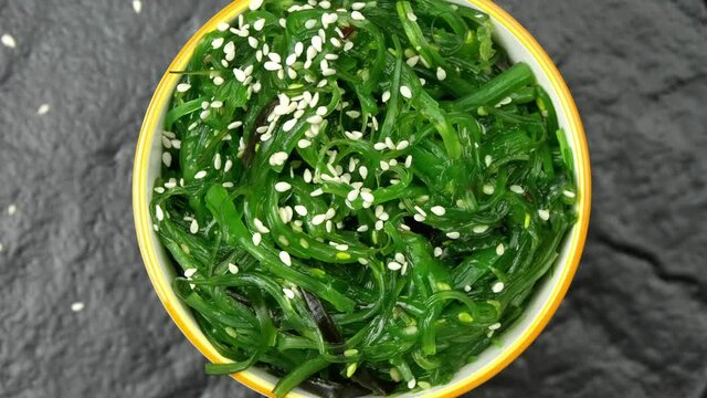 Rotating bowl with tasty seaweed salad, top view