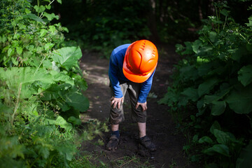 Child in a construction helmet. Orange helmet on the boy's head.