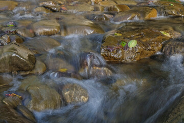 Clear water of the Carpathian mountain river. Long exposure photography. Evening golden hour.