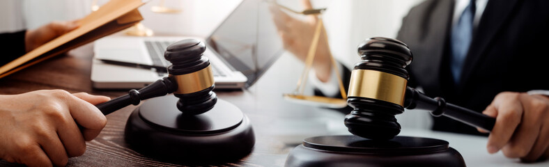 Justice and law concept.Male judge in a courtroom with the gavel, working with, computer and docking keyboard, eyeglasses, on table in morning light