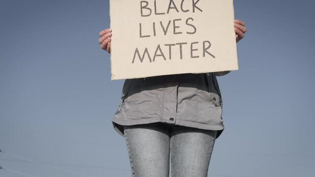 Anti Racism Demonstration. A Woman In A Protective Mask With A Sign BLACK LIFE MATTERS.