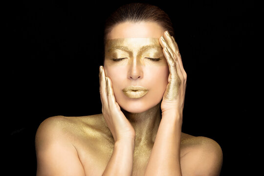 Beauty woman face with gold mask. Gold based skincare concept. Cosmetology and spa treatment