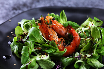 lunch dinner dish meal in a gourmet restaurant with fresh salad. food fish elegant gourmet plate. sea seafood shrimp on black plate