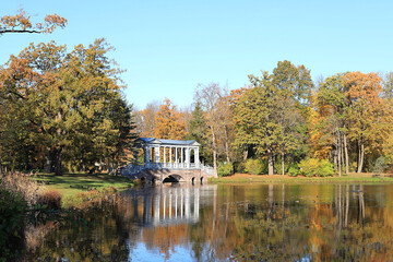 Obraz premium Russia, St. Petersburg, October 10, 2020, Alexandrovsky Park, Tsarskoe Selo. The photo shows an autumn pond with fallen leaves and the Marble Bridge. Beauty of the October forest, travel