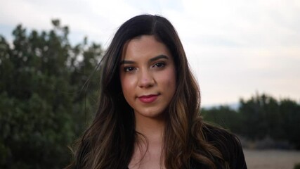 Attractive young independent adult hispanic woman looking with happy, smiling eyes at the camera with confidence and positivity for the future of human kind.