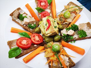 Veganer Brotzeit Teller, bunt mit Tomaten, Tofu, veganem Omlett und fermentiertem Gemüse