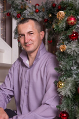 a man in a new year's interior sitting on a ladder. New year and Christmas