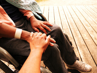 Close-up of a daughter supporting her disabled mother in a wheelchair.