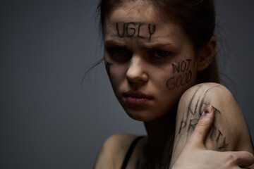 woman with offensive inscriptions on her body touching herself with hands stress frustration hate