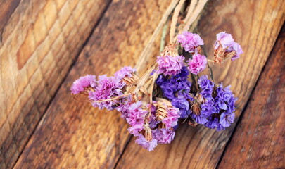 Dried statice flowers on a wooden background top view.