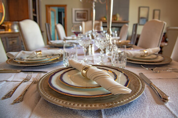 Stunning fancy diner party setting with full placed seats, wine glasses, plates, cutlery and napkins. 