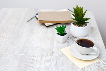 desk office with blank notepad, coffee cup and pen on wood table.