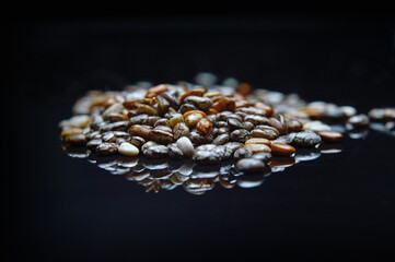 chia seeds on a black glossy surface close-up.