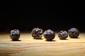 black pepper on a wooden surface. close-up.
