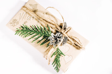 Christmas gift box decorated with pine cones and twigs on white background. Christmas presents and New Year. Handmade
