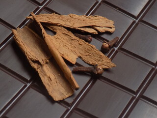 Canela y clavo de olor sobre tableta de chocolate