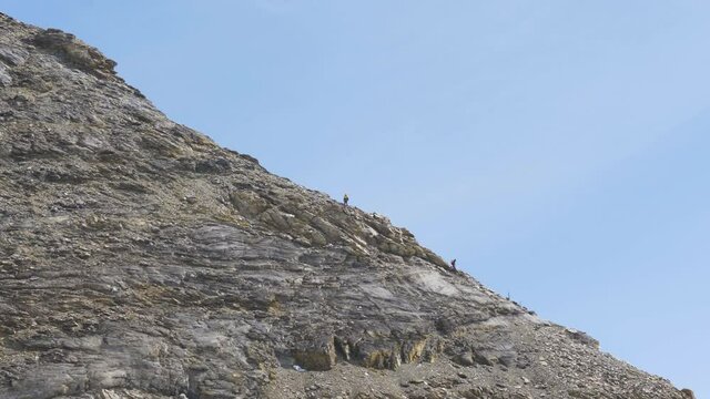mountain climbers going down rocky stones on the Jungfrau in Switzerland. Hard climbing on high alpine mountain slow motion
