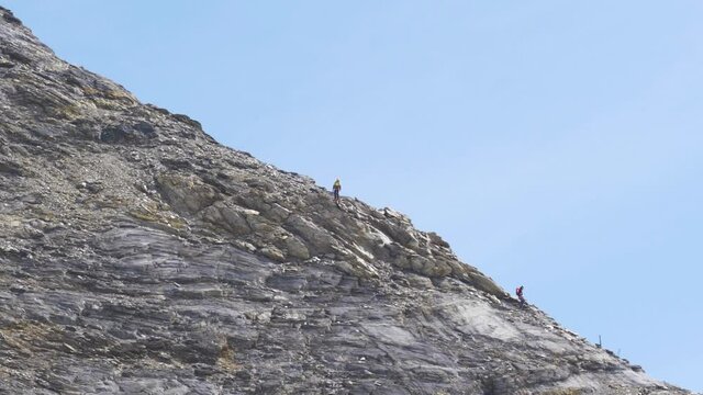 mountain climbers going down rocky stones on the Jungfrau in Switzerland. Hard climbing on high alpine mountain slow motion