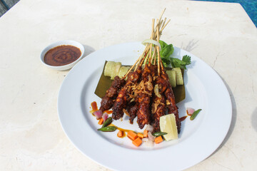chicken satay, sate ayam and lontong with peanut sauce