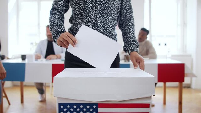 Unrecognizable man putting his vote in the ballot box, elections concept.