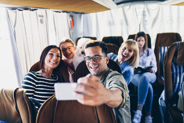 Happy travelers taking selfie photo in bus.
