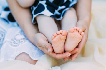 Mother gently hold baby leg in hand. soft focus on babies foot