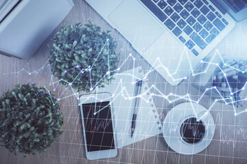 Multi exposure of financial chart hologram over desktop with phone. Top view. Mobile trade platform...
