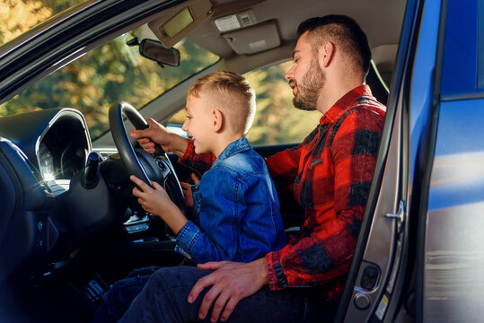 Handsome Father Pointing On Something While Teaching Teen Son Driving Car