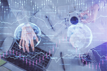 Fototapeta premium Multi exposure of man's hands typing over computer keyboard and forex graph hologram drawing. Top view. Financial markets concept.