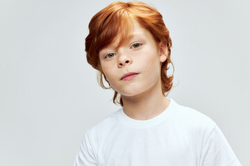 Portrait of redhead boy cropped view white t-shirt studio gray 
