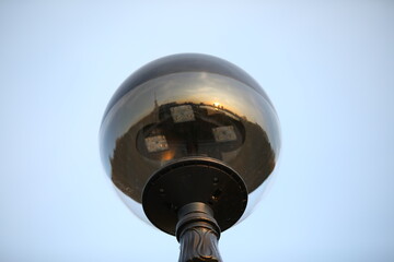 The lamp is isolated.Modern street light bulb with a metal base and a glass ball reflecting the light