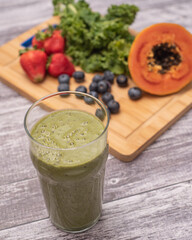 Smoothie green with fruits and kale in the background. Ideal for healthy eating signs or recipes