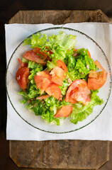 Plato de ensalada de tomate y lechuga con servilleta de papel de cocina.