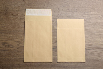 Kraft paper envelopes on wooden background, flat lay