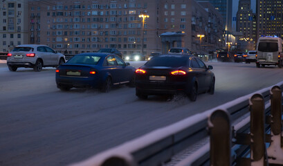 Cars move in the winter at night on the bridge