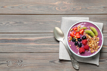 Delicious acai smoothie with fruits served on grey wooden table, top view. Space for text