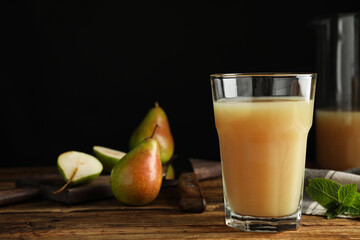 Fresh pear juice in glass on wooden table, closeup. Space for text