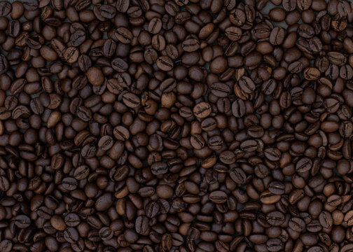 Dark roasted big sized beans of coffee background. Horizontal image.