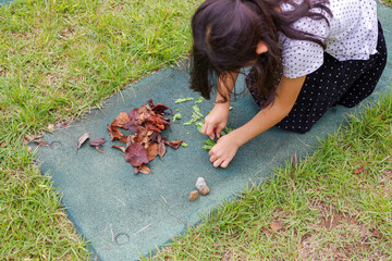 落ち葉で遊ぶ女の子