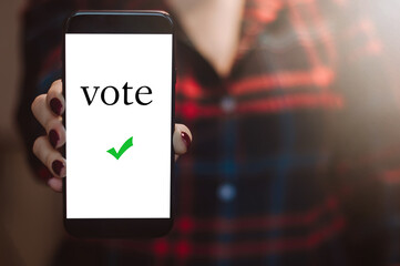 Woman votes online using the phone. Voting and elections concept.