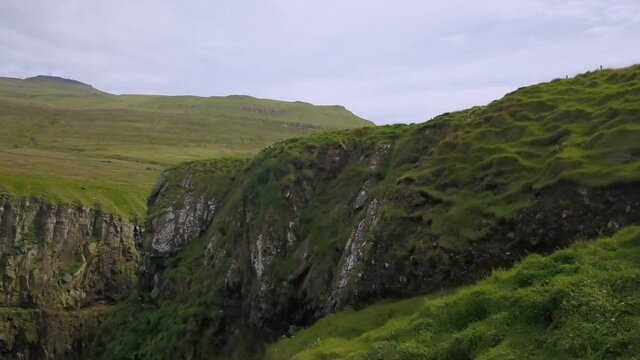 Green cliffs of farroe islands in cloudy weather. Drone aerial view.