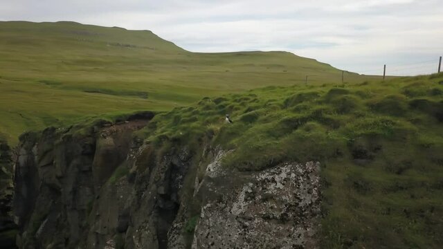 Green cliffs of farroe islands in cloudy weather. Drone aerial view.