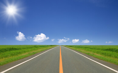 草原の直線道路と雲と太陽