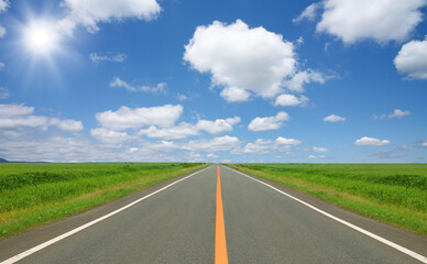草原の直線道路と雲と太陽